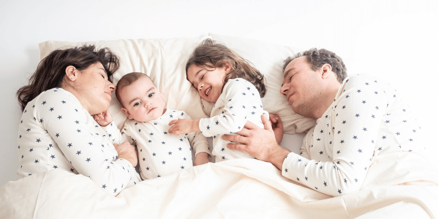 Famille au lit faisant des massages aux enfants