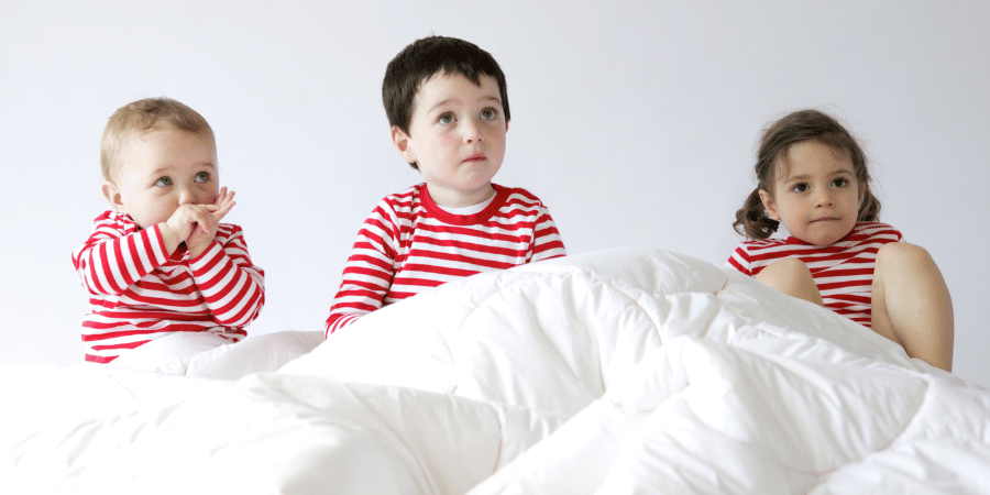 3 enfants dans un lit